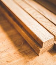In der Nahaufnahme erkennt man mehrere Holzleisten, die aufeinander gestapelt liegen.